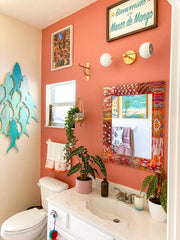 Peach bathroom with linear loa sconce in brass and white