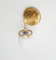 single brass bathroom sconce with glass West End