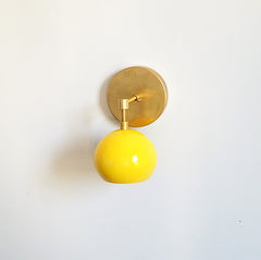 yellow and brass mid century style eyeball shade wall sconce