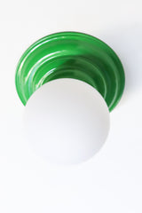 Stepping back into a bygone era with a touch of modern minimalism, the Abeille Sconce or Flushmount in bright green is an artistic blend of form and function. This wall sconce doubles as a flushmount ceiling light, making it a versatile lighting solution for any space. Designed akin to a beehive, its charismatic shape is complemented by curated color options that add a playful element to its retro appeal.
