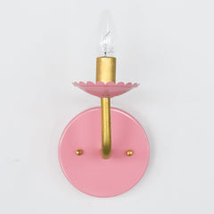 pastel pink and brass wall sconce with scalloped bobesche detail