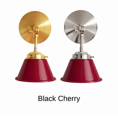 A burgundy red wall sconce with a glossy cone shade, shown in Black Cherry with brass or nickel hardware. It has a single light, a round backplate, and a swivel knuckle with a wing nut so you can angle the shade toward a bed, a mirror, or a counter. Use it as a bedside reading light, a vanity light next to a bathroom mirror, or a pair over a kitchen sink. Deep red pairs well with dark green walls, wood paneling, and warm brass, so it suits vintage, grandmillennial, and moody traditional rooms.