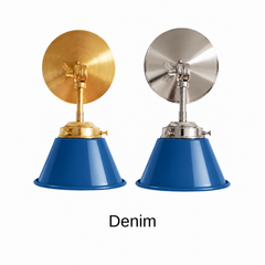 A denim blue wall sconce with a glossy cone shade, shown in Denim with brass or nickel hardware. It has a single light, a round backplate, and a swivel knuckle with a wing nut so you can tilt the shade toward a bed, a desk, or a mirror. Use it as a bedside reading light, a task light over a desk, or a pair by a bathroom mirror as a vanity light. Denim blue sits well with red or rust accents, gingham, and warm wood, so it suits farmhouse, Americana, and relaxed modern rooms.