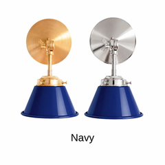 A navy blue wall sconce with a glossy cone shade, shown in Navy with brass or nickel hardware. It has a single light, a round backplate, and a swivel knuckle with a wing nut so you can angle the shade toward a bed, a mirror, or a sink. Hang one by a bed, a pair beside a bathroom mirror as a vanity light, or one over a kitchen sink. Navy looks crisp with white shiplap, striped fabrics, and polished brass, so it suits nautical, coastal, and classic traditional decor.