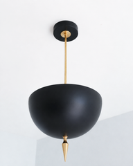 Black and brass pendant light with a bold spike finial, the Alexander Pendant sends light up instead of down, so the matte black dome bounces a warm glow off the ceiling while the fixture itself stays dramatic and dark. That uplight pendant design paired with the oversized art deco spike makes this the most masculine of the colorways, all matte black metal against polished brass hardware. Statement dining room pendant, moody entryway light, or maximalist ceiling fixture for dark academia decor and colorful 
