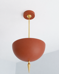 Terra cotta pendant light with a brass spike finial, the Alexander Pendant flips the usual dome shade upside down so light bounces up off the ceiling instead of down. That uplight pendant design plus the oversized art deco spike gives it a masculine, maximalist edge you don't see in typical colorful lighting. Matte terra cotta and brass hardware make this a standout dining room pendant, entryway light fixture, or statement ceiling light for maximalist home decor and colorful traditional homes that want some