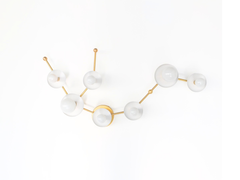 White Aquarius zodiac wall sconce in brass hardware with branching arms and white powder coated steel disc details, an astrology inspired star sign light fixture with a sculptural mid century modern feel for a bold bathroom vanity, hallway, or eclectic maximalist interior.