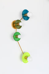 Aries modern color-block wall sconce in a juicy green palette, featuring glossy Lagoon teal, earthy Olive, bright Spring Green, and zesty Chartreuse disc shades on warm brass hardware; sculptural 4 light wall fixture with round saucer backplates and exposed globe bulbs, designed like graphic wall art; statement mid century modern lighting for a maximalist home, dopamine decor, and bold colorful interior design; perfect for a green kitchen, playful powder room, eclectic hallway, modern entryway, or a kid or 