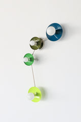 Colorful Aries constellation wall light with four disc shades, teal blue, olive green, bright green and lime chartreuse, chrome hardware and globe bulbs, modern sculptural sconce for bathroom vanity lighting, bedside reading, entryway accent light, contemporary and retro interior design, photographed on clean white.