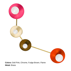 Colorblocked Aries wall sconce with four round saucer disc shades in doll pink, cream, fudge brown, and flame orange, connected by sleek brass arms with white globe bulbs, photographed on a clean white background. Sculptural modern lighting for a pretty powder room, feminine bathroom vanity, eclectic bedroom, colorful hallway, mid century modern living room, or playful kids room, an instant pop of color for maximalist and modern decor.