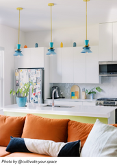 Three teal Astro pendant lights with brass stems and layered geometric disc shades installed in a row over a kitchen island; colorful modern lighting for a contemporary kitchen, mid century modern home, and playful maximalist interior design—perfect statement pendant trio for an island, open concept kitchen, dining area, or breakfast bar that brings bold color and designer style.