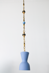 Centered full length product photo of a pastel blue pendant light suspended from a brass beaded chain with green marble bead details and a blue bead accent, a one of one artisan statement pendant that fits mid century modern decor, grandmillennial interiors, coastal style, playful kids room lighting, nursery ceiling light, and colorful modern pendant lighting for kitchens and hallways