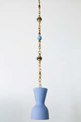 Centered full length product photo of a pastel blue pendant light suspended from a brass beaded chain with green marble bead details and a blue bead accent, a one of one artisan statement pendant that fits mid century modern decor, grandmillennial interiors, coastal style, playful kids room lighting, nursery ceiling light, and colorful modern pendant lighting for kitchens and hallways
