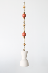 One of a kind cream pendant light with a sculptural hourglass shade hanging from a brass beaded chain, featuring terracotta round beads and light teakwood accent beads, a modern mid century inspired statement pendant for maximalist design lovers, perfect over a kitchen island, breakfast nook, entryway, nursery, or kids room lighting.