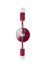 Medium Thalia Sconce shown vertically from the side with a glossy Black Cherry finish, chrome hardware, and two white globe bulbs. This slim two-light wall sconce brings a colorful modern look to bathrooms, powder rooms, hallways, bedrooms, and vanity areas, with a deep red-burgundy color that pairs beautifully with marble, white walls, patterned wallpaper, and polished chrome fixtures.