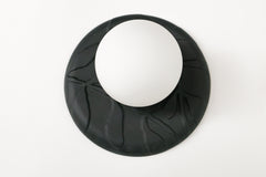 Matte black unglazed porcelain wall sconce with raised leafy relief and frosted glass globe, sculptural modern ceramic lighting