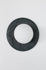 Front view of matte black unglazed porcelain sconce, leaf-textured ceramic backplate with frosted globe shade on white background