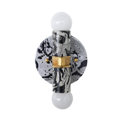 Studio close-up emphasizing the sculptural silhouette of the Thalia sconce: globe bulb, cylindrical socket, and round backplate, all finished in a black-and-white hand-marbled pattern. The brass hardware adds a jewelry-like touch that pairs beautifully with marble, terrazzo, checkerboard floors, and classic subway tile. A great keyword fit for modern eclectic lighting, minimalist glam bathrooms, monochrome maximalist interiors, and boutique hotel bath lighting.