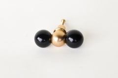 A double-ball cabinet knob pairing two glossy black spheres with a polished brass ball at the center, giving it more presence than a standard single knob. A moodier, more serious option than the brighter colorways, good for a black kitchen, a masculine study, or anywhere that wants a graphic, sculptural pull instead of a plain one.