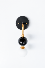 A closer crop of the black and brass Ida sconce, showing the stacked black glass orb and small brass ball accents in more detail. Useful for seeing the proportions and finish before choosing it for a bathroom, hallway, or entry.