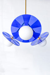 Close-up photo: Intricately etched acrylic disc in bright blue adds a playful touch to the Circus Chandelier.