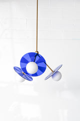 Mid-century modern pendant light fixture with bright blue, etched acrylic discs.