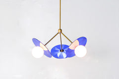 blue and brass midcentury modern op-art inspired chandelier features etched acrylic discs and brass hardware with diffused glass globes