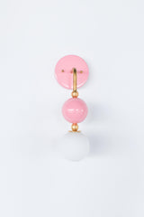 The Ida Sconce in blush pink stacks a hooked brass arm, ribbed brass ball joints, and a glossy pink powdercoated sphere above a soft white opal glass globe, giving the whole fixture a jewelry-like silhouette on the wall. It works well as a bedside light in place of a table lamp, beside a bathroom mirror, or anywhere a single statement sconce makes more sense than a matching pair.
