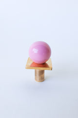 Studio image of a blush pink and brass square gumball knob, featuring a glossy pink ball on a square raw brass base with cylindrical stem. Perfect for mid-century modern furniture, playful cabinet hardware, and custom kitchen or dresser drawer accents.