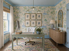Botanico chandelier in a soft, feminine home office with blue trim, scenic floral wallpaper, a pale green writing desk, botanical art, floral rug, and a curved wood credenza. The green botanical chandelier adds sculptural overhead lighting that feels fresh, artistic, and garden-inspired without losing polish. A beautiful fit for grandmillennial decor, colorful home office design, chinoiserie wallpaper rooms, cottage style interiors, floral maximalism, and statement office lighting.