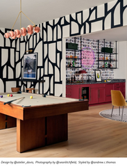 Bold game room and home bar featuring a peach Calliope chandelier in brass, styled over a pool table with graphic black and white wall art. Maximalist modern decor includes burgundy bar cabinets, open shelving, photo wallpaper, and a neon sign. Great keywords for contemporary chandelier lighting, designer game room ideas, and statement pendant fixtures. Calliope chandelier by Sazerac Stitches.