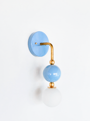 Pastel Blue and shiny brass modern geometric wall sconce with a soft white globe.  Great sculptural fixture for bedrooms, bathrooms, nurseries, and more. Versatile baby blue pastel color looks great with everything.