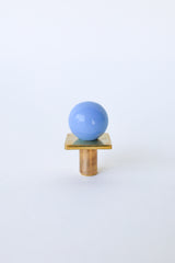 Celestial Blue Square Gumball Drawer Pull with unlaquered brass base, shown on a vintage wood dresser. This colorful cabinet knob features a glossy pale blue powder-coated sphere and square brass backing—perfect for modern kids’ rooms, bathrooms, kitchens, or colorful interiors.