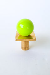 Close-up of a chartreuse and brass square gumball knob featuring a vibrant glossy neon green ball on a raw brass square base with cylindrical stem. Modern cabinet hardware for colorful kitchens, midcentury modern furniture, and custom drawer or dresser pulls. Handmade and made to order.