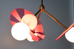 Close-up photo: Intricately etched acrylic disc in medium Pink adds a playful touch to the Circus Chandelier
