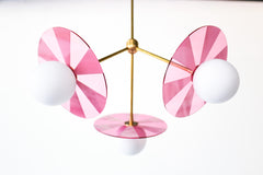 transparent medium pink and brass etched acrylic disc chandelier by sazerac stitches.  perfect Playful light fixture for nursery.