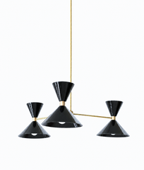 Black and brass is the pairing that makes a room feel sharp, sophisticated, and effortlessly cool, and this mid-century modern Clancy chandelier nails it. Three glossy black double-cone shades radiate from a brass central hub on slim brass arms, in a fun, sculptural MCM silhouette that throws light up and down from each arm. The warm brass stem and collars keep the black from feeling heavy and give the whole piece a polished, collected edge. It's built to be the star over a dining table, kitchen island, or 