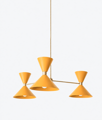 A warm mustard-yellow chandelier that brings sunny, vintage-cheerful color to a breakfast nook, dining room, or kitchen. The Clancy Chandelier pairs three splayed brass arms with soft golden-yellow hourglass double-cone shades, each hung at a slightly different height for a relaxed, asymmetric silhouette. This mellow yellow rides the butter-and-golden trend while feeling timeless, lovely against warm wood, English florals, or creamy millwork. A cheerful color statement for English cottage, grandmillennial, 