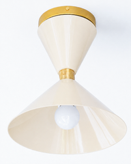 Cream and Brass flushmount ceiling light in a mid-century modern style light fixture. Great for small spaces, to bring in a little more color and design. We love this in a brightly colored bathroom, a pantry, a statement closet, an art room and more!