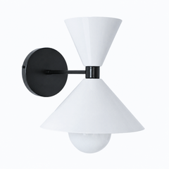 A crisp black-and-white wall sconce that brings clean, graphic contrast to a powder room, hallway, or bedside. The Clancy Sconce carries the same sculptural double-cone shade as the Clancy chandelier, a wide cone below and a smaller cone flaring up above, here in glossy white with a matching black collar, arm, and round backplate. The white-on-black pairing reads modern and a little architectural, sharp against a dark wall, patterned tile, or bright white trim. A clean, versatile pick for modern, minimalist