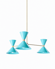 A breezy poolside-aqua chandelier with a Palm Springs feel, made for a dining room, sunroom, or kids' space that wants happy, retro color overhead. Each of the three arms ends in an oversized double-cone shade, a broad cone below that throws light down and a smaller cone flaring up above, joined at a raw brass collar. The arms hang at staggered heights off a central brass hub so the fixture reads loose and sculptural, and the drop can be sized to your ceiling. This light aqua is cheerful and a little vintag