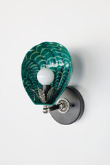 Unique sculptural wall sconce in mermaid green with hand-painted shell-shaped shade and expressive brushwork; chrome-toned decorative hardware and black wall mount complete the coastal-meets-deco aesthetic