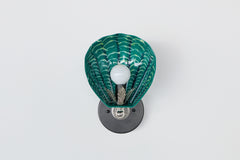 Modern Art Deco wall sconce with hand-painted green ceramic shell in a sea-inspired palette; mounted on matte black round backplate with vintage-style chrome detailing, custom one-of-a-kind light