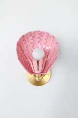 Full frontal shot of the whimsical pink Coquille sconce with leafy socket cup, hand-applied squiggle motif on powder-coated steel, and solid brass mounting hardware – artistic handcrafted lighting fixture perfect for colorful interiors, New Orleans–inspired design, or bold bathrooms