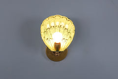 Front-facing view of the Coquille hand-painted wall light featuring a scalloped steel shade in custom-mixed greens like vista green and olive, hand-brushed and clear powder-coated for protection, finished with brass fittings and a glowing G16.5 bulb, suitable for mid-century modern and coastal decor themes