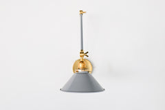 Grey and Brass adjustable cone sconce for kitchen lighting above windows or above open shelving cabinetry.  Also makes a great bedside reading light that frees up space on your nightstands. Comes in three finishes and over 30 colors for a custom look.  Available in neutrals or fun, bright colors that work in any maximalist or kid-friendly space.  Classic style wall sconce that has been updated by our curated color palette of brights, darks, and pastel hues.  Designed and made by Sazerac Stitches.
