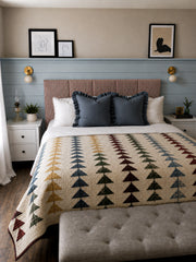 Cozy bedroom styled with a pair of Cream and Brass Loa wall sconces flanking the bed on a pale blue shiplap accent wall. The compact globe-and-dome sconces feature warm brass backplates and soft cream shades, creating simple, modern bedside lighting that feels both vintage-inspired and clean-lined. A striped upholstered headboard, crisp white bedding, and a colorful traditional quilt add layered texture, while white nightstands and framed minimalist art complete the calm, collected look. Great inspiration f