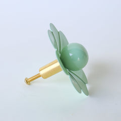 Bring a soft, refreshing touch to your space with the Mint Daisy Knob by Sazerac Stitches. This charming drawer pull, designed in a delicate daisy shape with mint green petals and a rounded center, is perfect for adding a vintage-inspired accent to any cabinet or drawer. Ideal for creating a soothing, whimsical vibe in nurseries, bathrooms, or other cozy spaces.