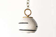 Neutral cream and black speckled geometric pendant lamp with oversized brass loop on brass chain.  Boho style modern Pendant light that can be swagged.  Textural pendant that is perfect for neutral spaces.  Adds a handmade quality to a space.  Designed and assembled in New Orleans.  The ceramic shades are made in North Carolina.