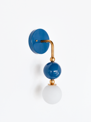 A denim blue and brass wall sconce built for colorful bathroom vanity lighting, powder room sconces, or coastal bathroom ideas. The stacked glass orb and brass hardware give it more shape than a standard fixture, good for interior designer resource lighting or custom lighting for interior designers working in a coastal traditional or Southern interiors direction.